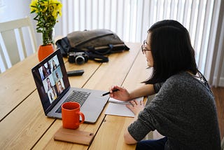 A woman working at home participating in a team video conference call.