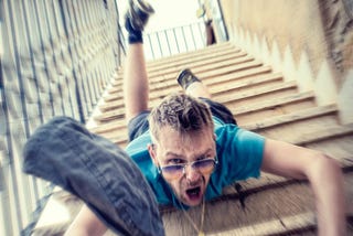 man in shorts and sunglasses falling down the stairs with a scared look in his face