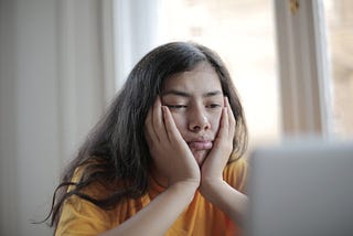 A woman staring frustrated at her laptop screen