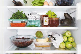 The inside of a fridge full of veggies.