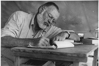Ernest Hemingway writing on a desk