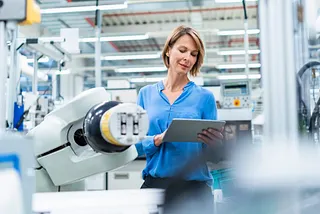 A woman with a tablet at a factory.