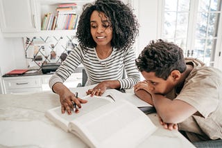 A mother helping her son study and read.