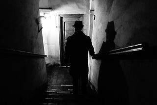 noir-style photograph of a figure descending a staircase