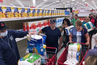 Customers rush to purchase toilet paper at a Target store during panic shopping.