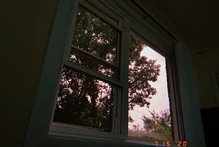 Photo dated to 7/15/2020 of a window with slightly light pink sky.