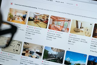 In this photo illustration, a man looks at listings on the Airbnb website.