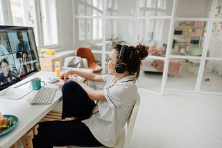 Young woman sitting at a desk and participating in a video conference.