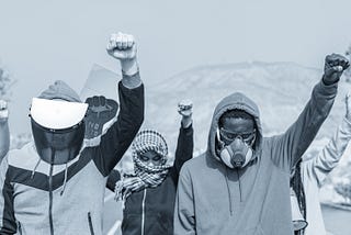 Monochrome image of activists raising fists as they protest.