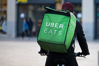 A Uber Eats courier rides a bike through the city center.