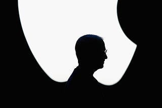 A silhouette of Steve Jobs’ profile against the Apple logo during the 2004 Apple Worldwide Developers Conference keynote.