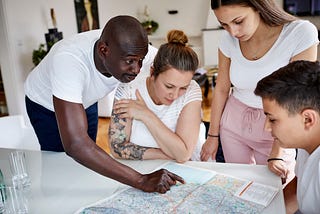A family looks at a map at home.