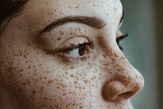 Closeup of woman’s face with freckles.