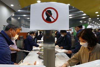 A photo of a sign that prohibits not wearing a face mask at a South Korean cafeteria.