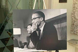 A picture of Malcolm X on an easel.