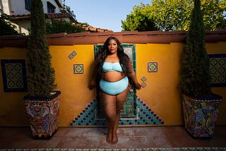 A photo of Nicole Byer posing in a swimsuit.
