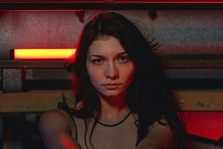 A moody potrait of a woman using red and orange lights.
