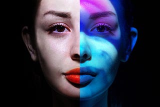 Woman face portrait with blue and purple lighting on half her face.