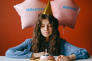 A woman wearing celebrating her birthday alone, a resigned expression on her face.