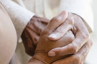 A photo of someone holding another’s hands.
