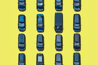 An aerial view of 16 blue cars on yellow background.