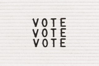 “Vote” written on a letter board.