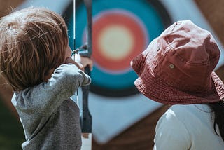Woman and Child with bow at archery target practice
