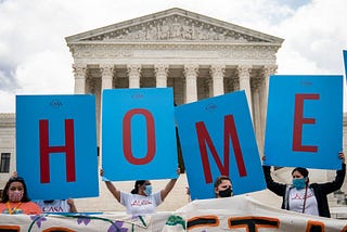 DACA supporters hold up signs that read “HOME” outside the Supreme Court on June 18th, 2020.