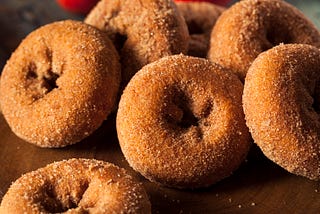 Cinnamon-sugar donuts on a table.