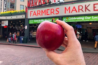 A Cosmic Crisp apple in front of a public market.