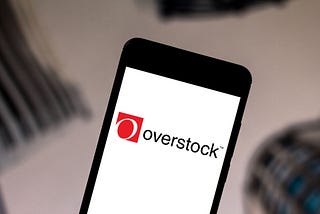 A photo of the Overstock logo on a smartphone.