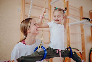 Child and coach at gymnastics practice.