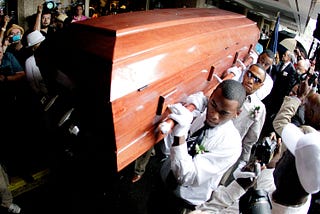 A photo of pallbearers carrying a casket at a homegoing in 2012.