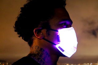 Man wearing LED light-up face mask at night.