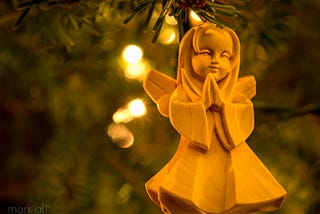 An angel Christmas ornament, hanging from a tree