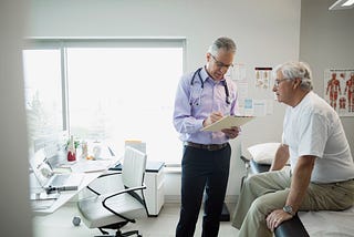 A doctor reviews the medical chart of a senior male patient.
