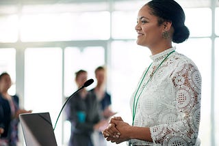 A young businesswoman confidently delivers a presentation at a conference