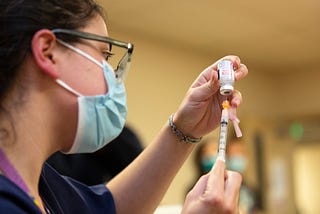 A female clinical pharmacist with Seattle Indian Health Board (SIHB) administers a shot of the Moderna COVID-19 vaccine, to frontline workers at the SIHB on December 21, 2020 in Seattle, Washington.