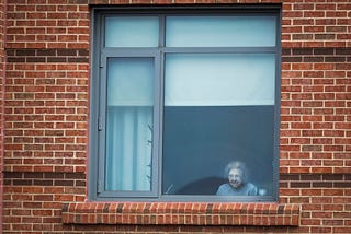 An older female resident at The Leonard Florence Center for Living looks outside her window.