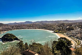 A picture of the serene waters of La Concha Bay and the quiet beach during springtime was taken from the top of Mount Igeldo.