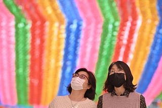 A photo of two Korean women wearing face masks at Jogyesa Temple in South Korea.