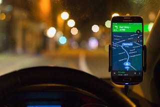 Google Maps on a phone mounted above a car dashboard.