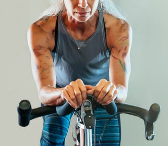 A female Peloton rider facing the camera, looking determined
