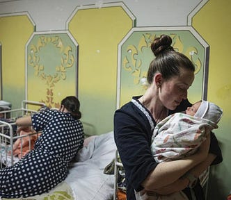 A woman holds a newborn inside a Ukrainian hospital