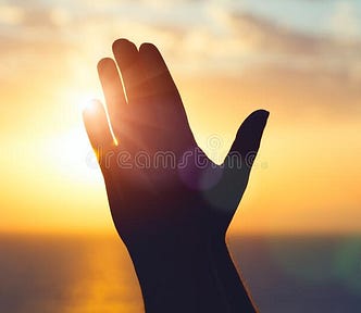 An image of hands closed in prayer with a backdrop of a sunrise.