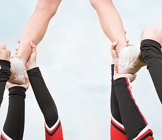 A cheerleader being supported by her team
