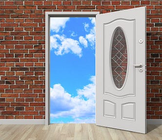 Image of a red brick wall with an ornate white door with a decorative glass window, opening to a blue, cloud-filled sky