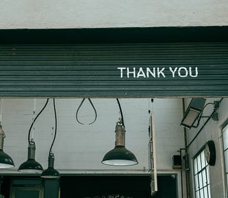 “Thank You” written on a door of a garage.