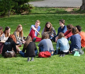 A group of young people sitting on the grass