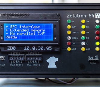Photograph of the front panel of a homemade computer, with an LCD panel, multiple LEDs and a label reading: Zolatron 64.